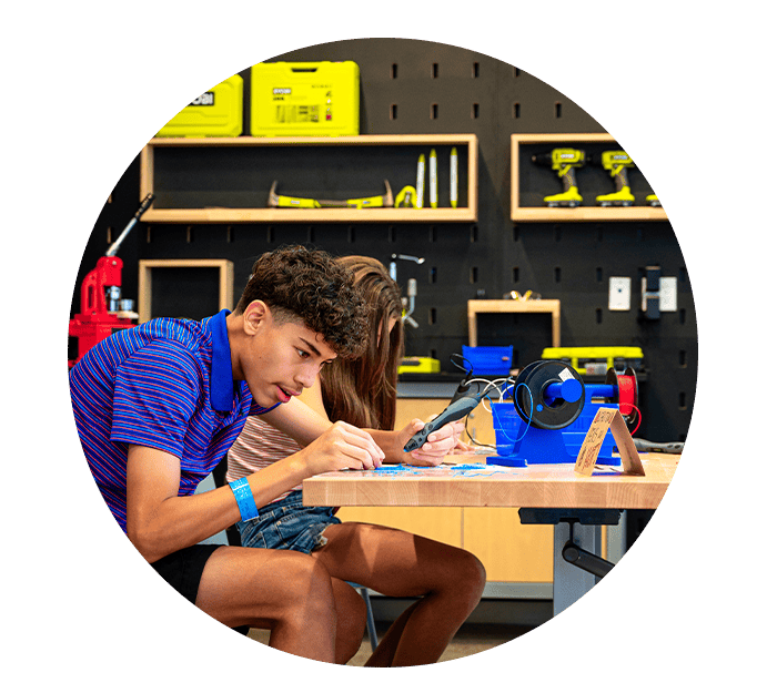 A boy and girl at a desk 3-D printing.