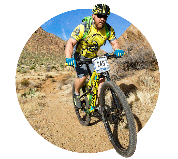 Guy riding bike down mountain trail