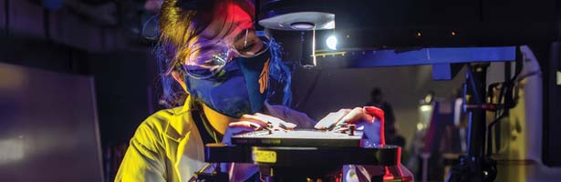 Girl with mask working on manufacturing project