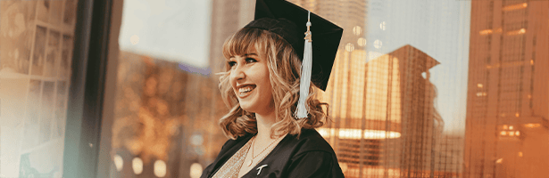 Girl in graudation hat and gown smiling