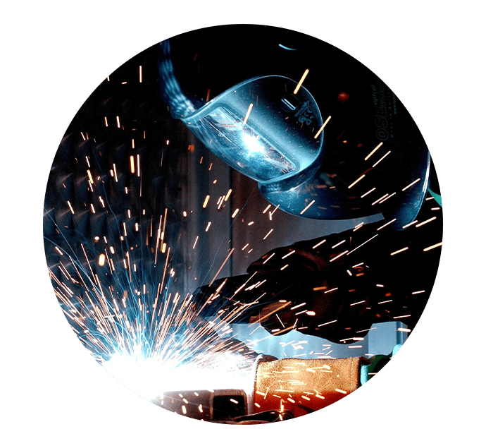 Man with welding mask welding object with sparks flying everywhere