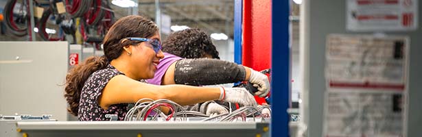 Two women working on manufacutring line with drills